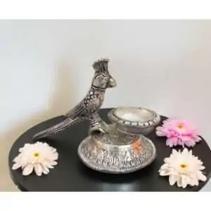 Metal diya deepak oil lamp wick lamp with parrot design for pooja rituals, festive home décor, and myth-inspired blessings; traditional Indian home spiritual decoration